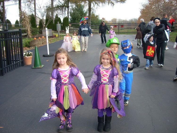 A group of children in costumes are walking down a street