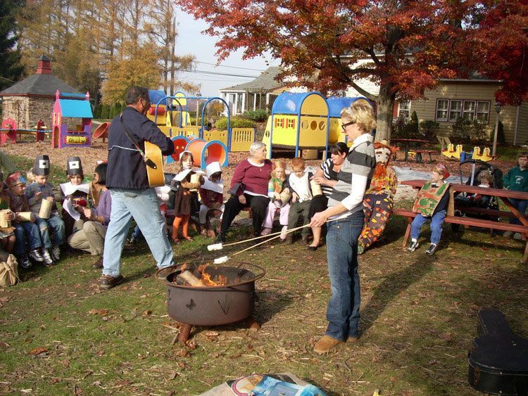 A group of people are roasting marshmallows over a fire pit