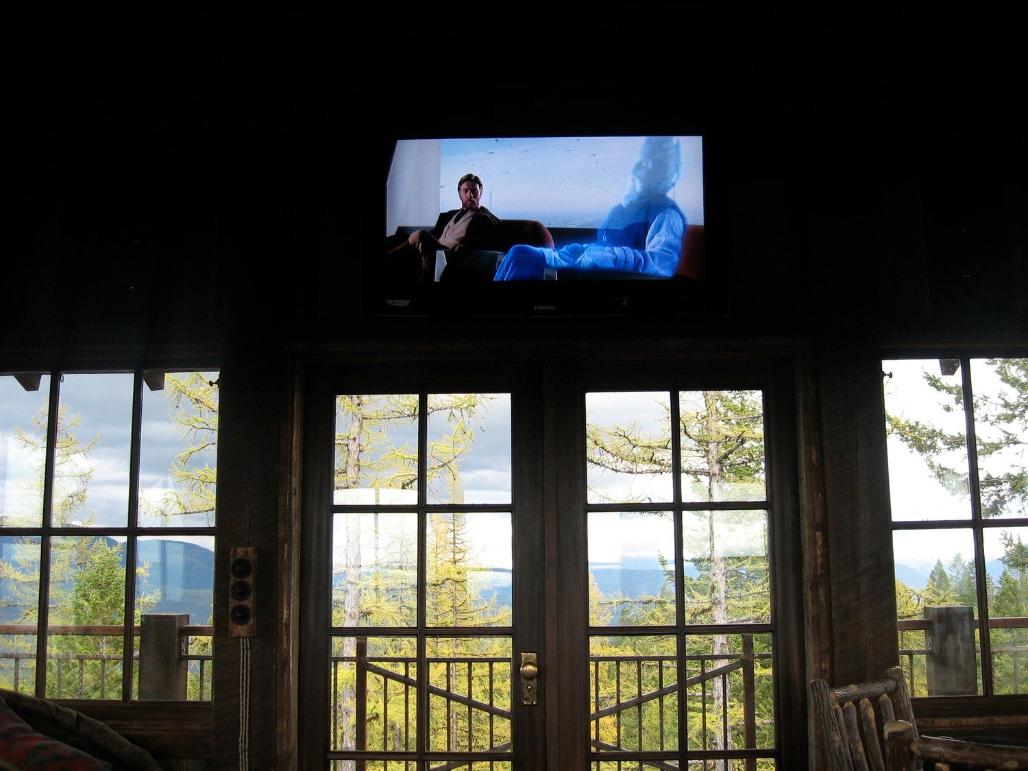 A man in a tuxedo is sitting on a couch in front of a television.