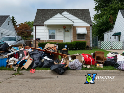Large residential curbside eviction cleanout with piles of trash bags and furniture in Las Vegas by Hot Mess Cleanup & Junk Removal.