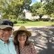 A man and a woman are posing for a picture in a park.