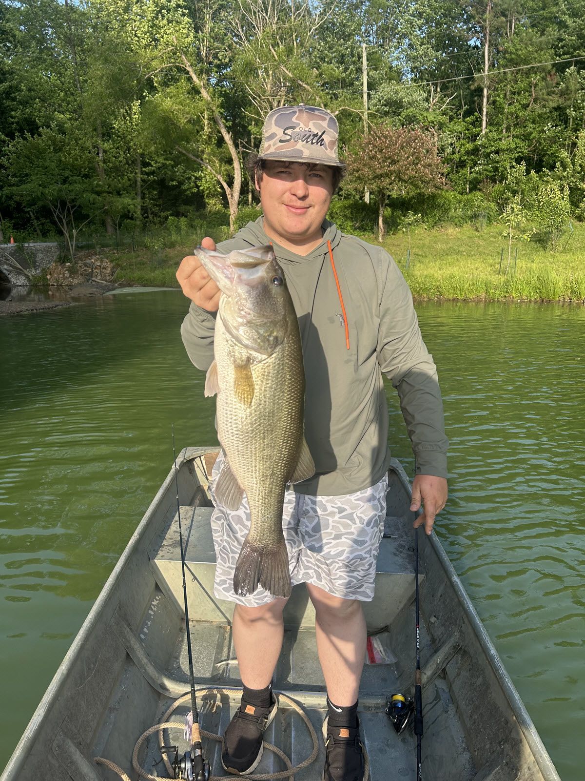 A man in a boat is holding a large fish.