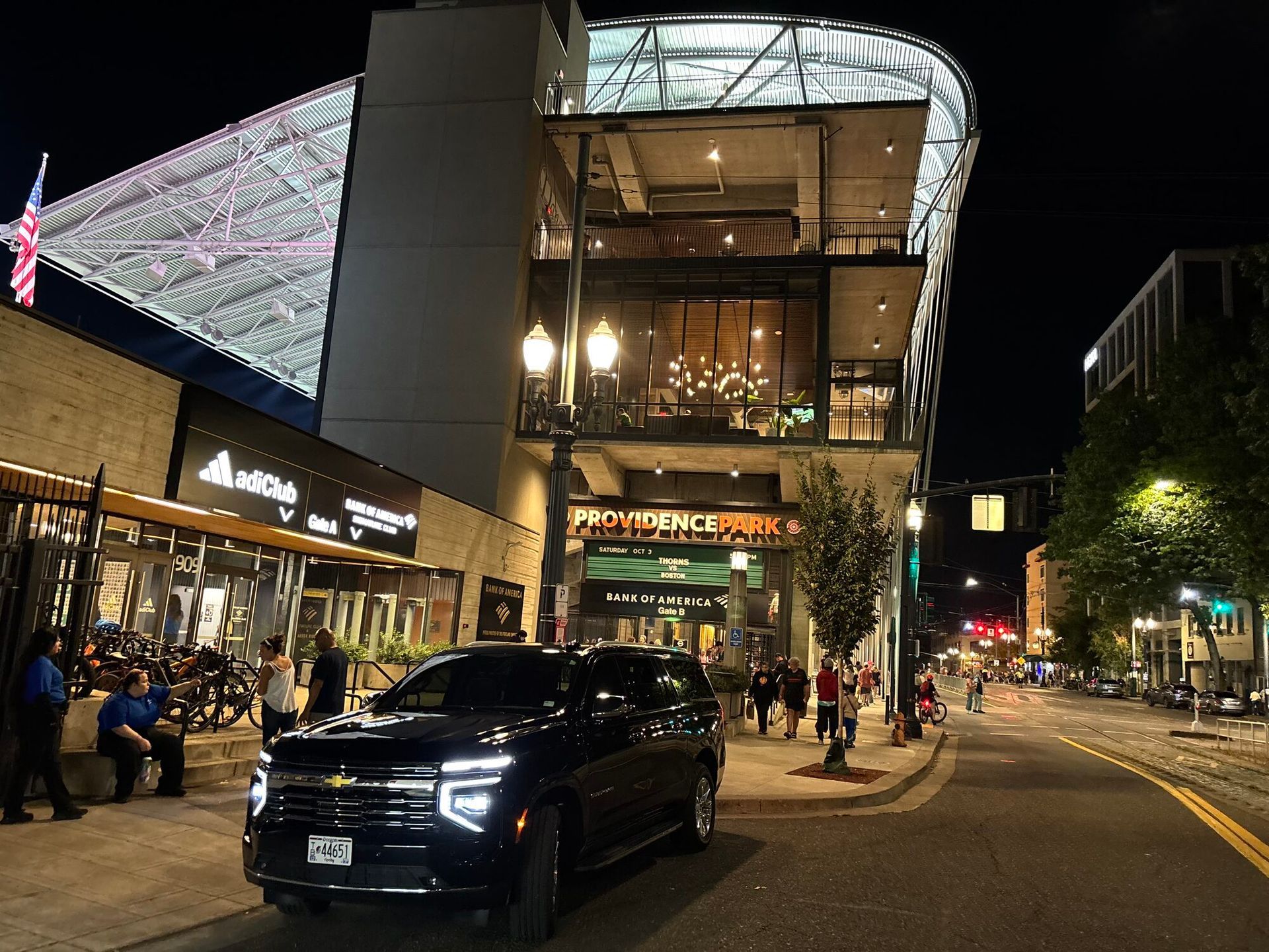 Black 2026 Chevrolet Suburban waiting at night outside Providence Park in downtown Portland for a concert pickup