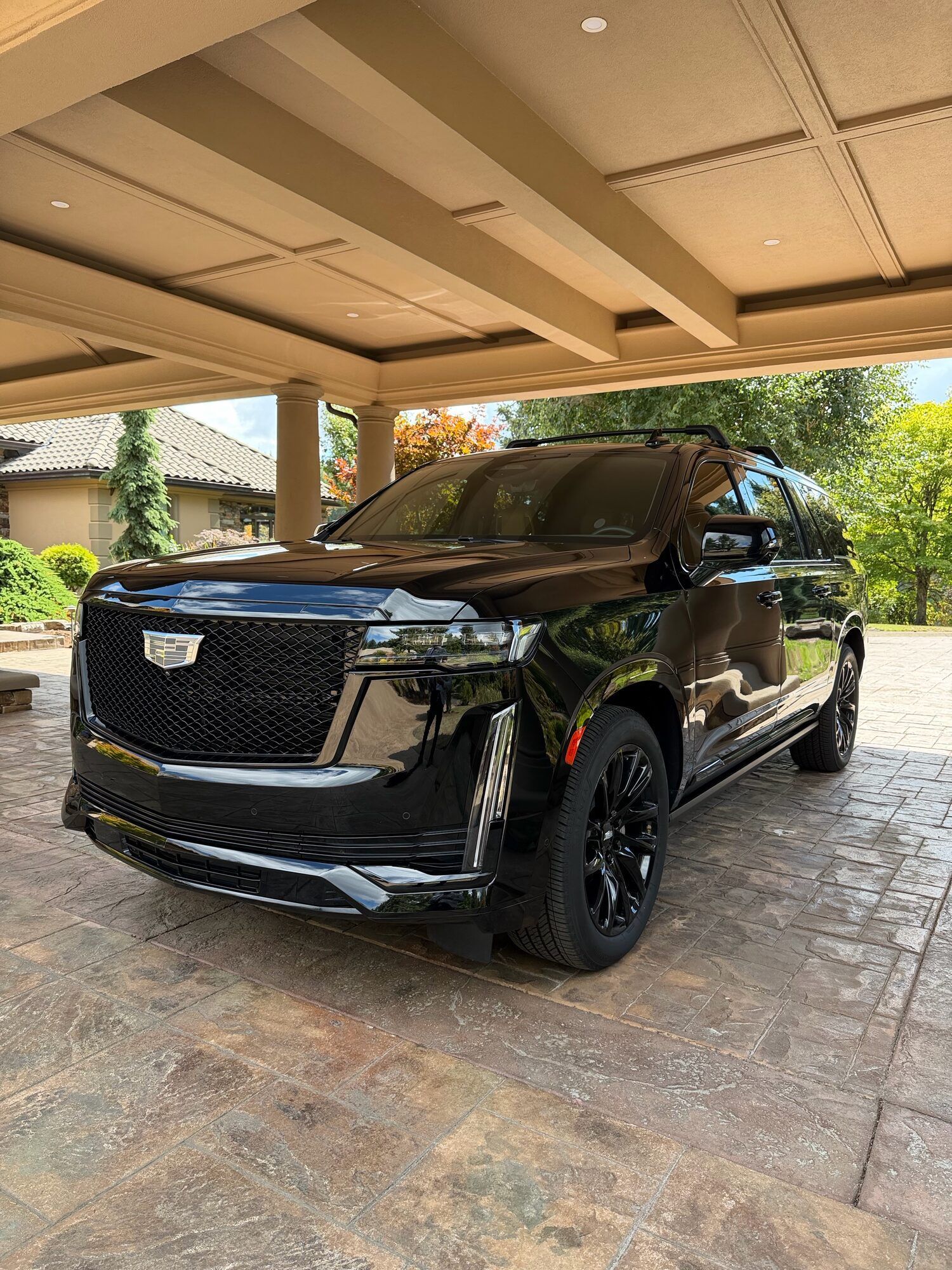 Black Cadillac Escalade parked under a covered entry, ready to carry a couple on their Portland wedding day