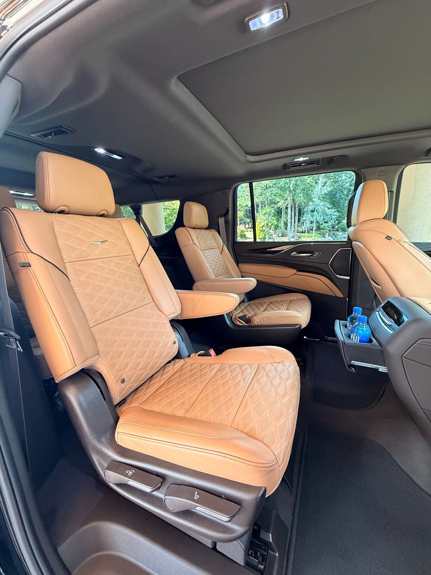 Quilted tan leather captain's chairs in the rear of a black Cadillac Escalade used for game night limo service in Portland
