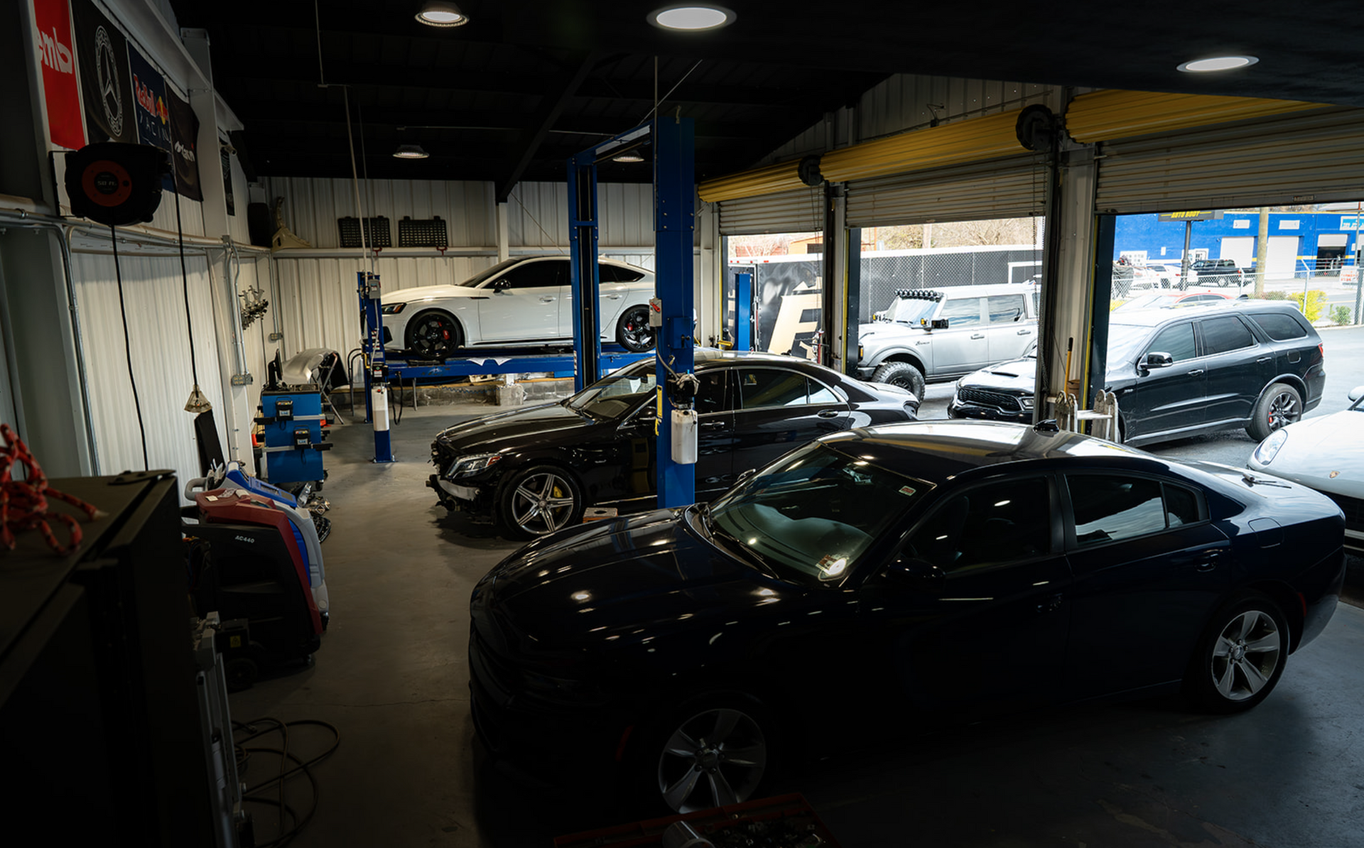 Indoor car showroom with several parked vehicles and blue support columns.