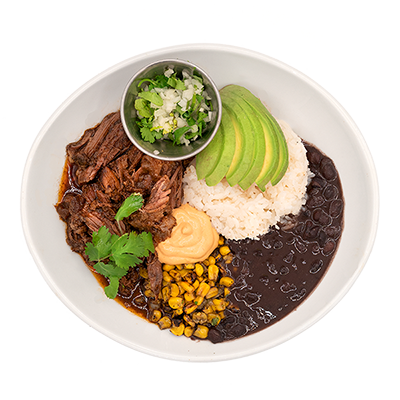 Plate of rice, black beans, shredded beef, avocado slices, corn, and garnish with a small side salad