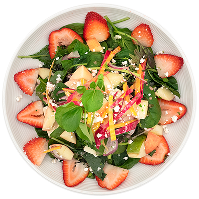 Fresh mixed salad with strawberries, greens, and colorful vegetables on a white plate