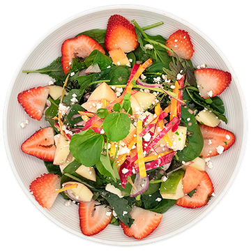 Fresh mixed salad with strawberries, greens, and colorful vegetables on a white plate
