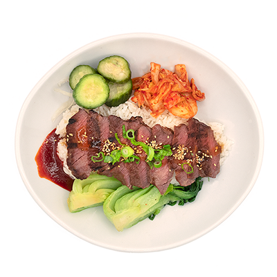 Bowl of sliced beef rice bowl with cucumber, kimchi, and greens on a white plate