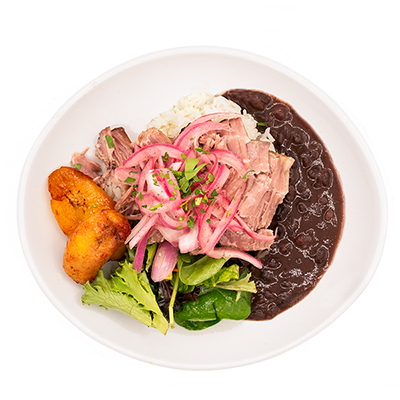 Top-down view of a plated rice bowl with sliced meat, pickled onions, greens, plantains, and black beans