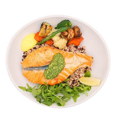 Salmon fillet with quinoa, vegetables, greens, and lemon on a white plate