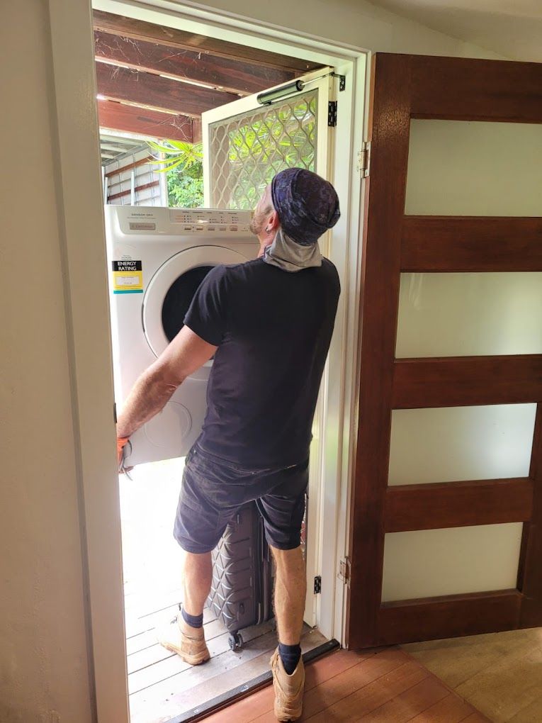 A Man is Carrying a Washing Machine Through a Doorway — Ready To Move in Tweed Heads, NSW