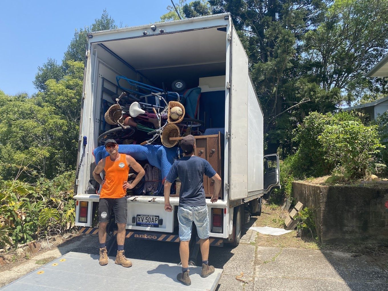 Two Men Are Standing Next to a Moving Truck Filled With Furniture — Ready To Move in Pottsville, NSW