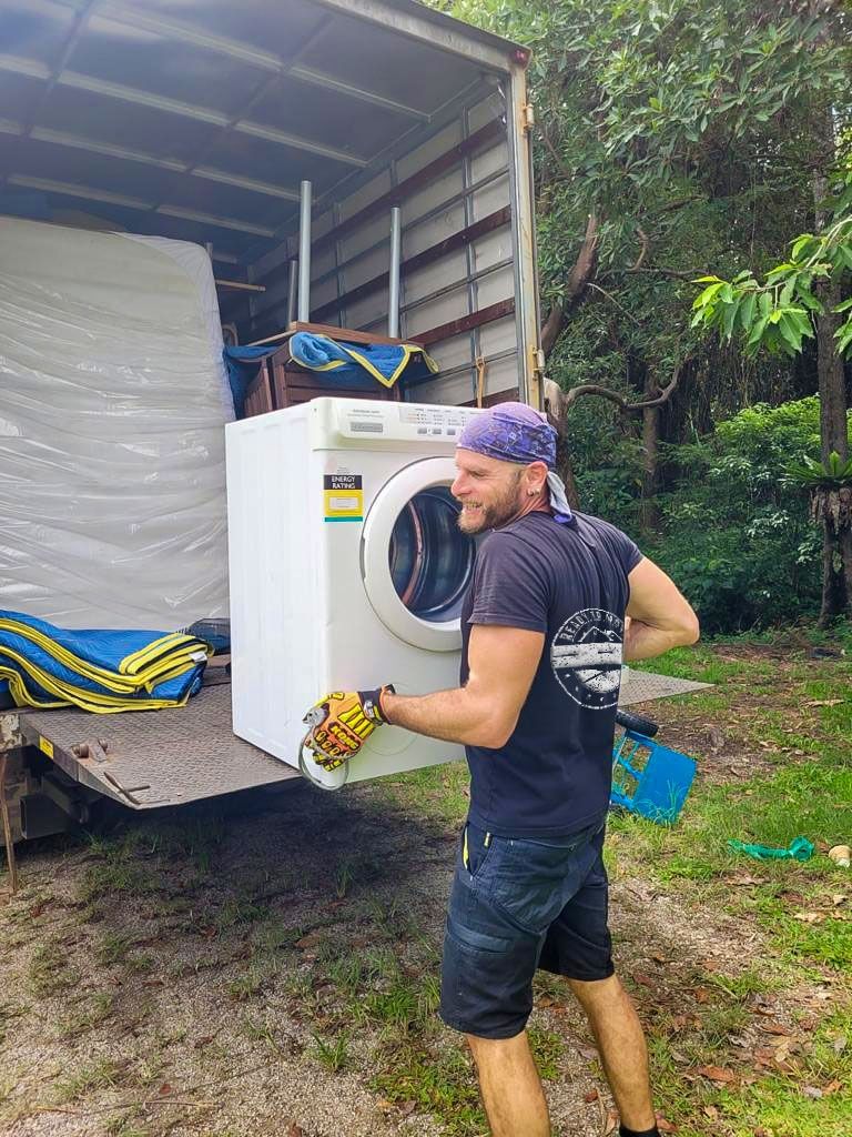 A Man is Carrying a Washing Machine Out of a Truck — Ready To Move in Ocean Shores, NSW