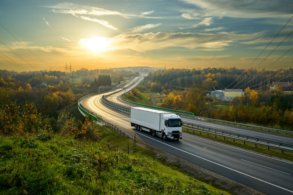 A White Truck is Driving Down a Highway at Sunset — Ready To Move in Bangalow, NSW