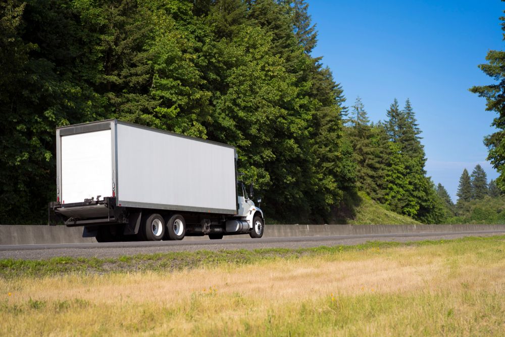 A White Truck is Driving Down a Highway Next to Trees — Ready To Move in Brunswick Heads, NSW