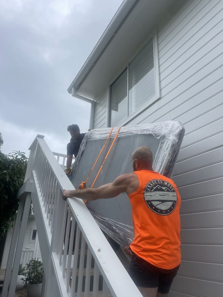 Two Men Are Carrying a Mattress Up the Stairs of a House — Ready To Move in Murwillumbah, NSW