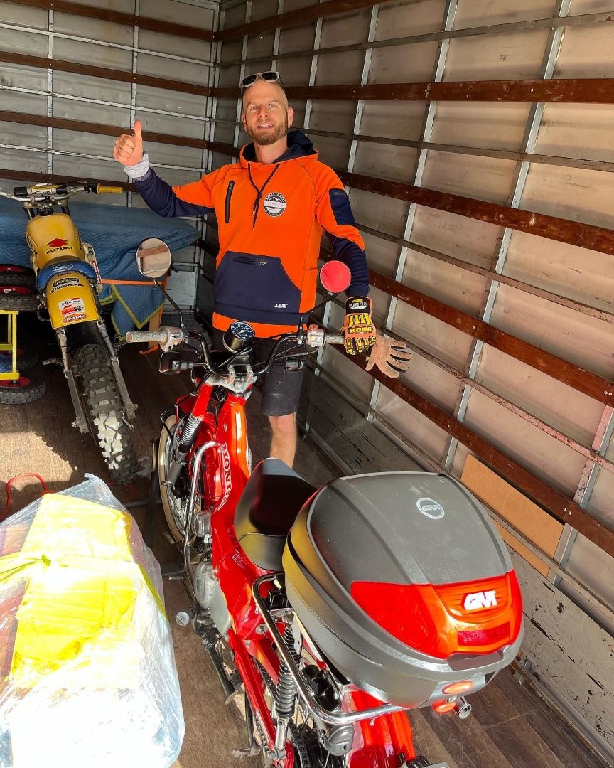 A Man is Standing Next to a Red Motorcycle in a Truck — Ready To Move in Ocean Shores, NSW