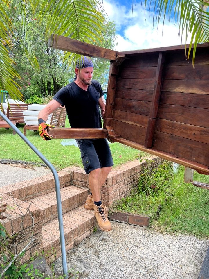 A Man is Carrying a Wooden Table Up a Set of Stairs — Ready To Move in Ballina, NSW