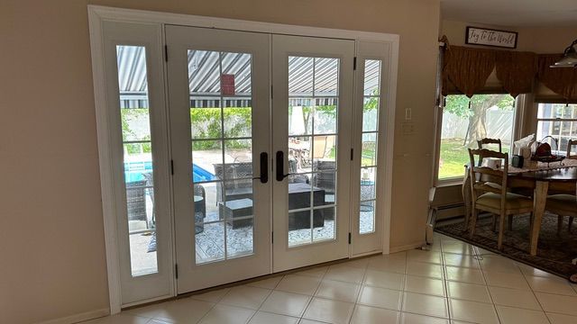 White French doors open to a patio from a tiled indoor dining area.