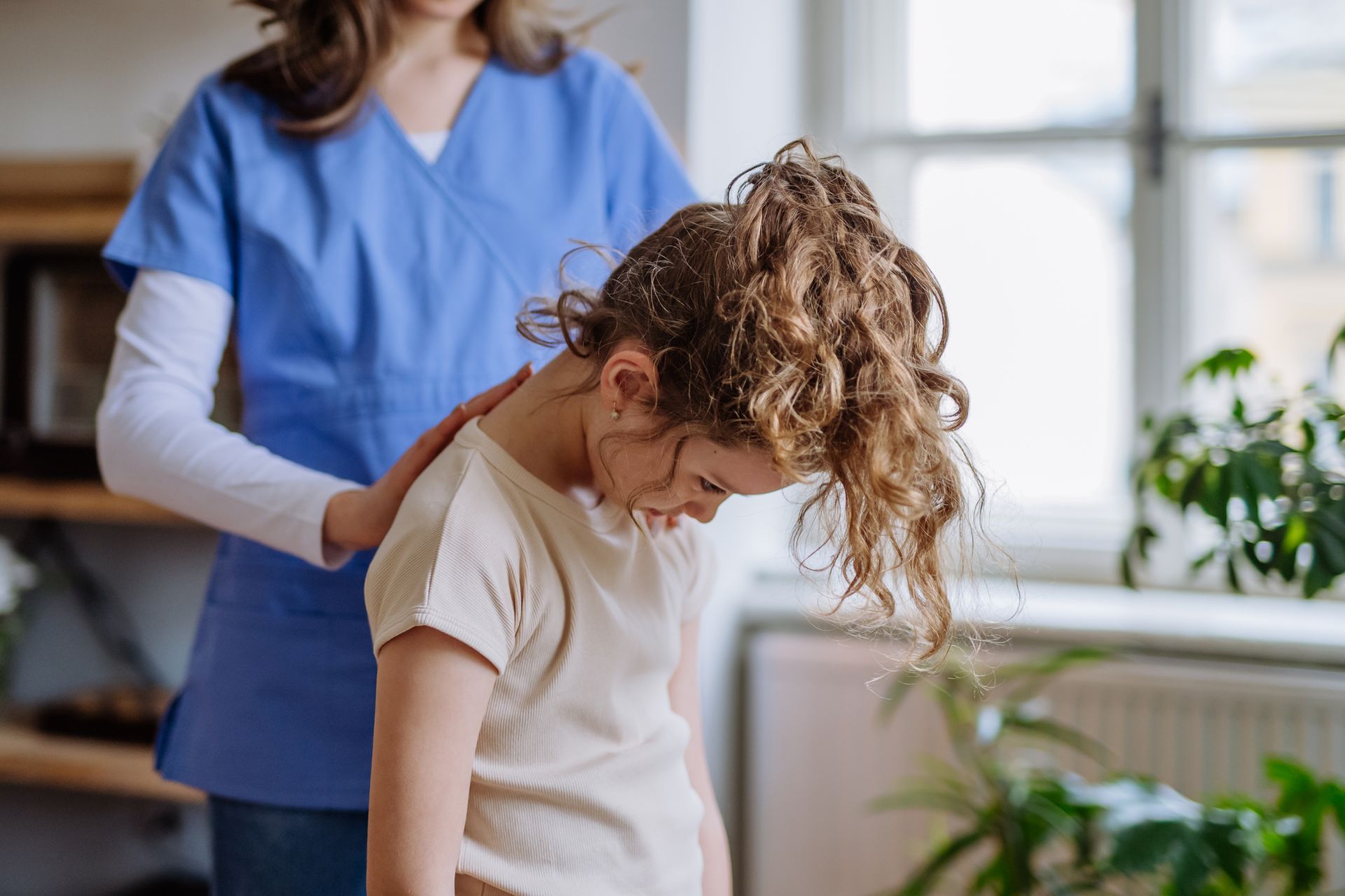 A young girl is getting a massage from a nurse.