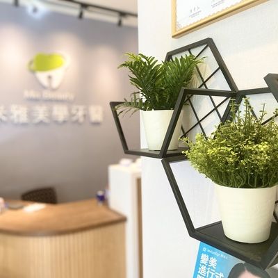 A shelf with potted plants on it in a dental office.