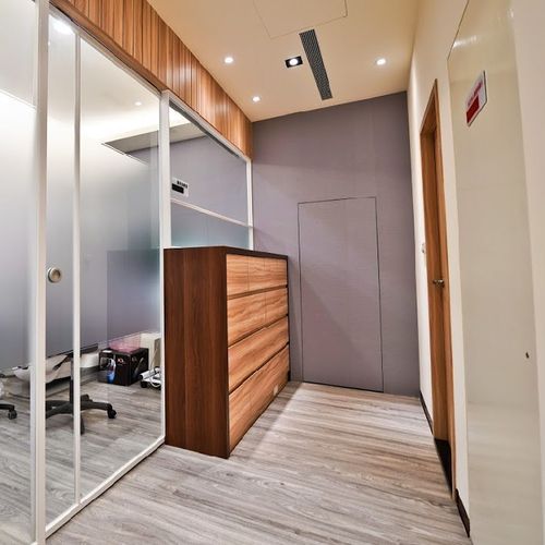 A hallway with a wooden dresser in the middle of it.
