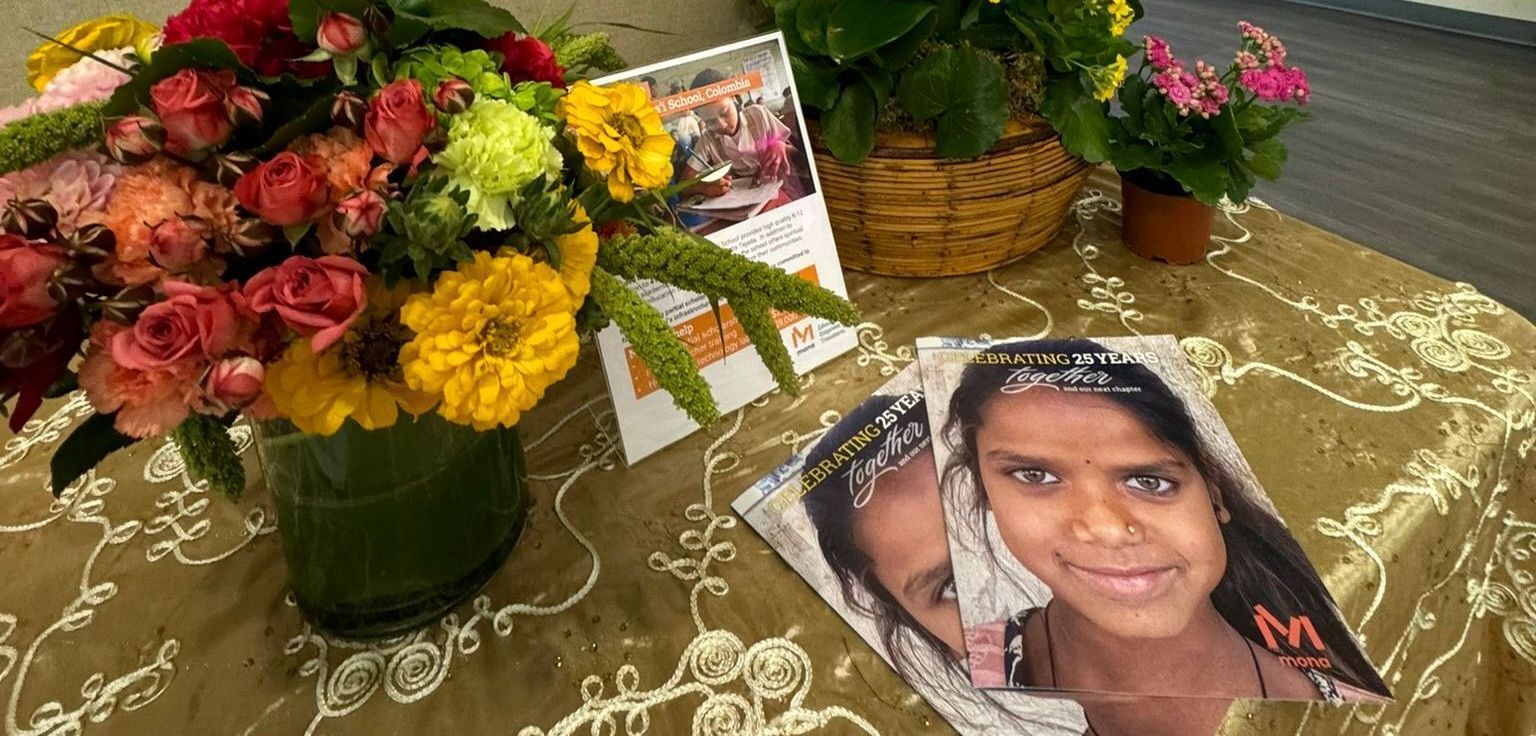 A table with a vase of flowers and a magazine with a picture of a girl on it.