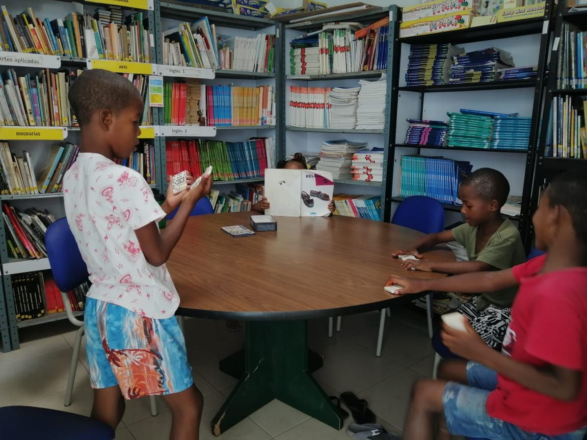 A group of children are playing cards in a library