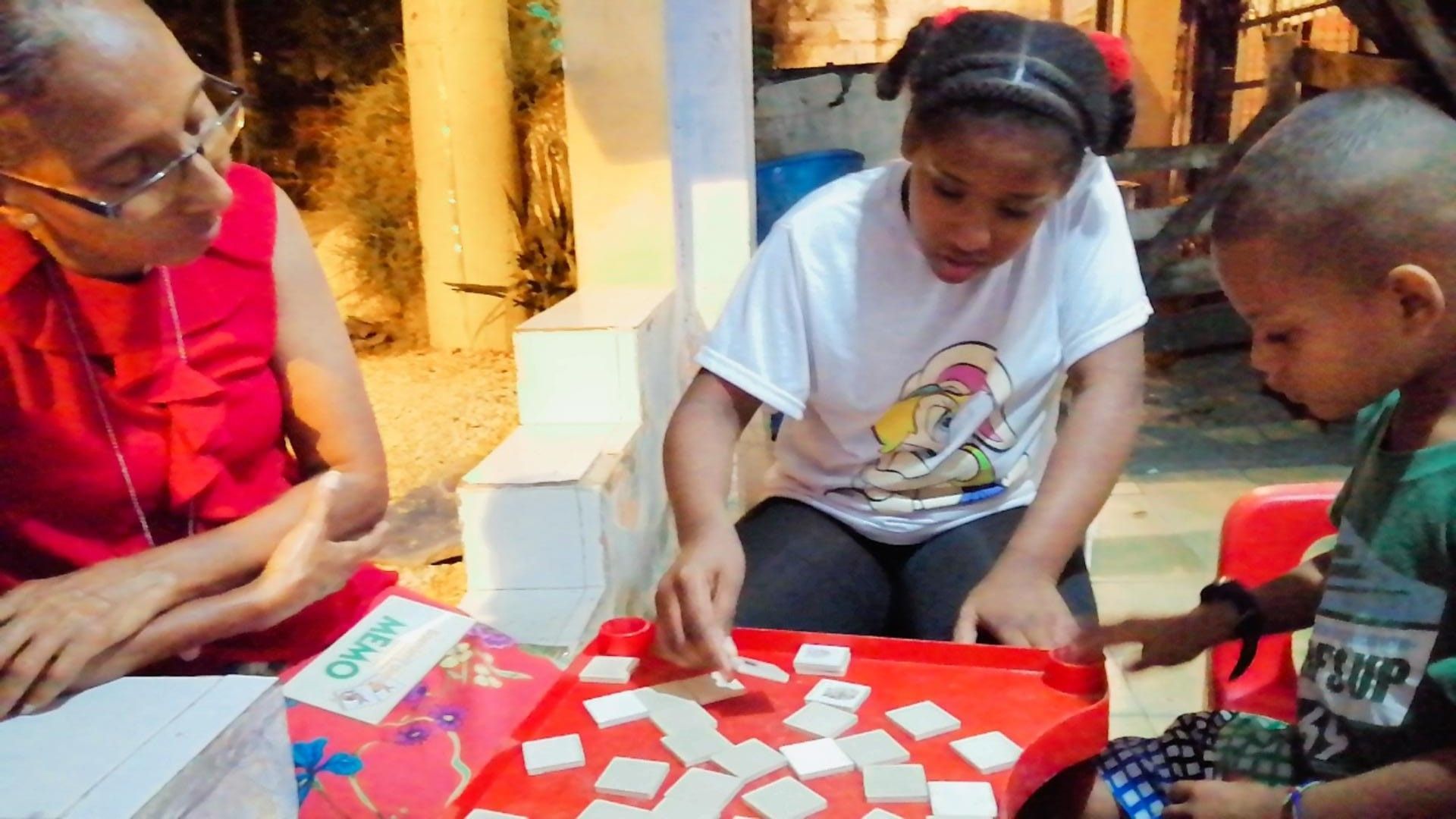 A group of children are sitting at a table playing a game.