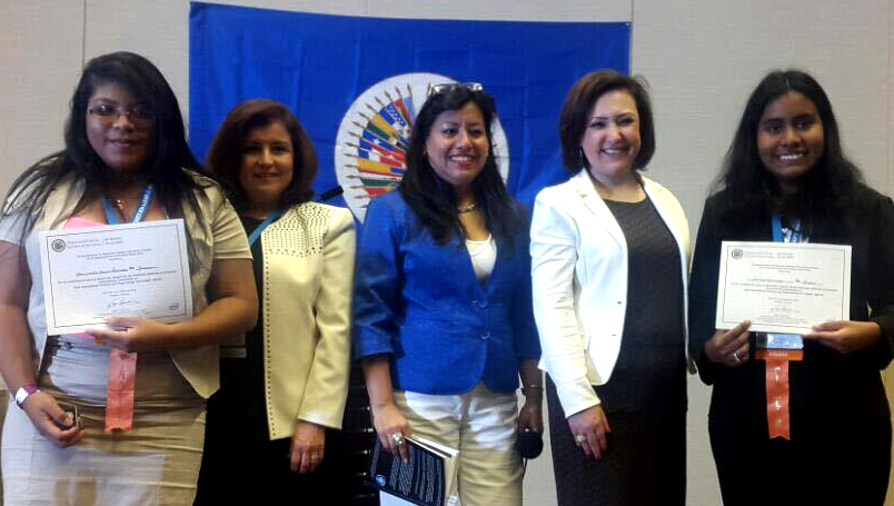 A group of women are posing for a picture in front of a flag