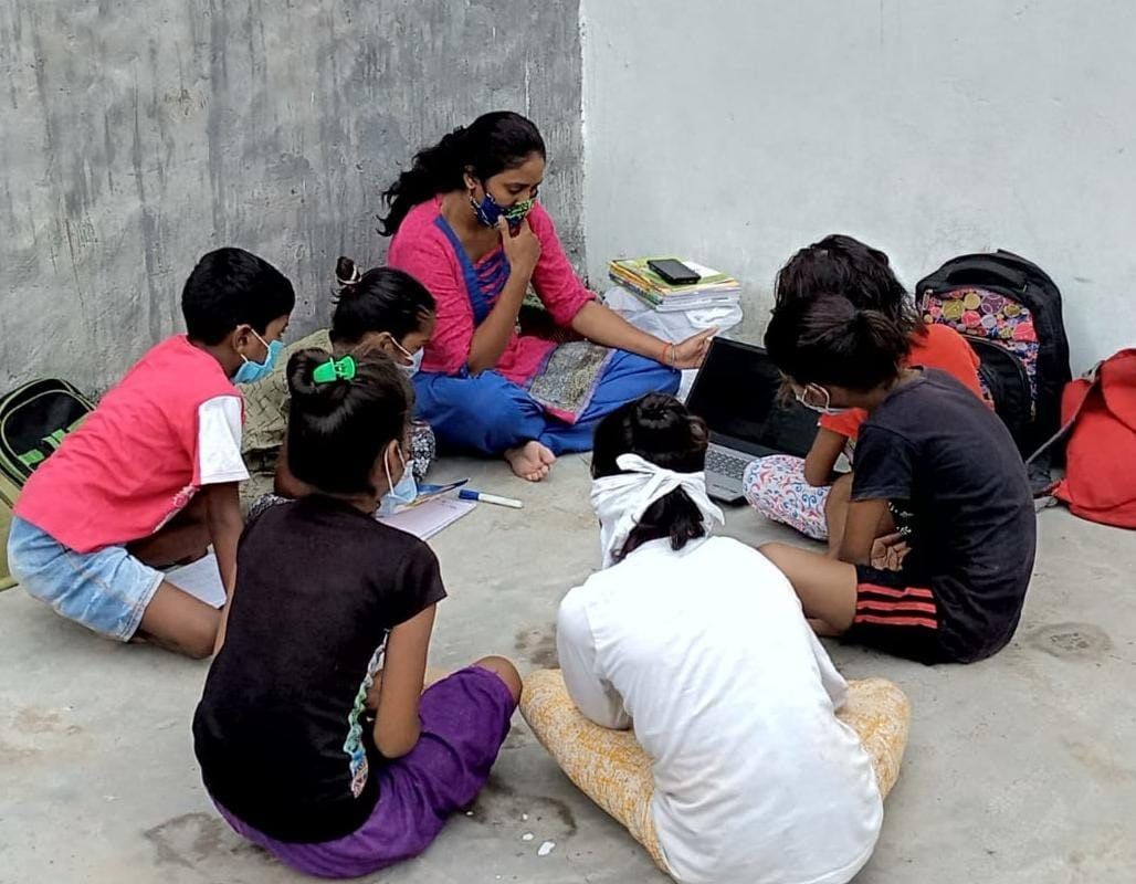 A group of people are sitting on the ground in a circle.