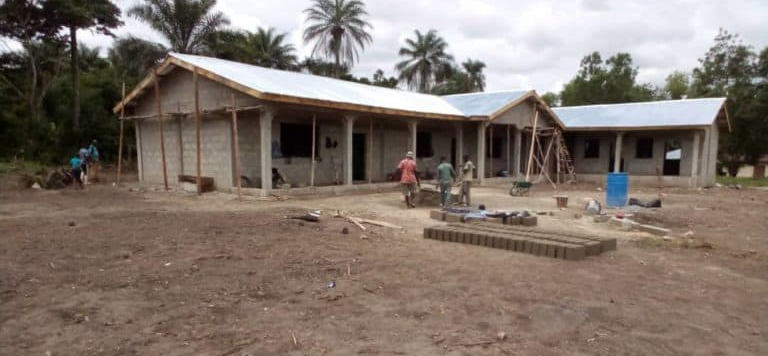 A house is being built in the middle of a dirt field.