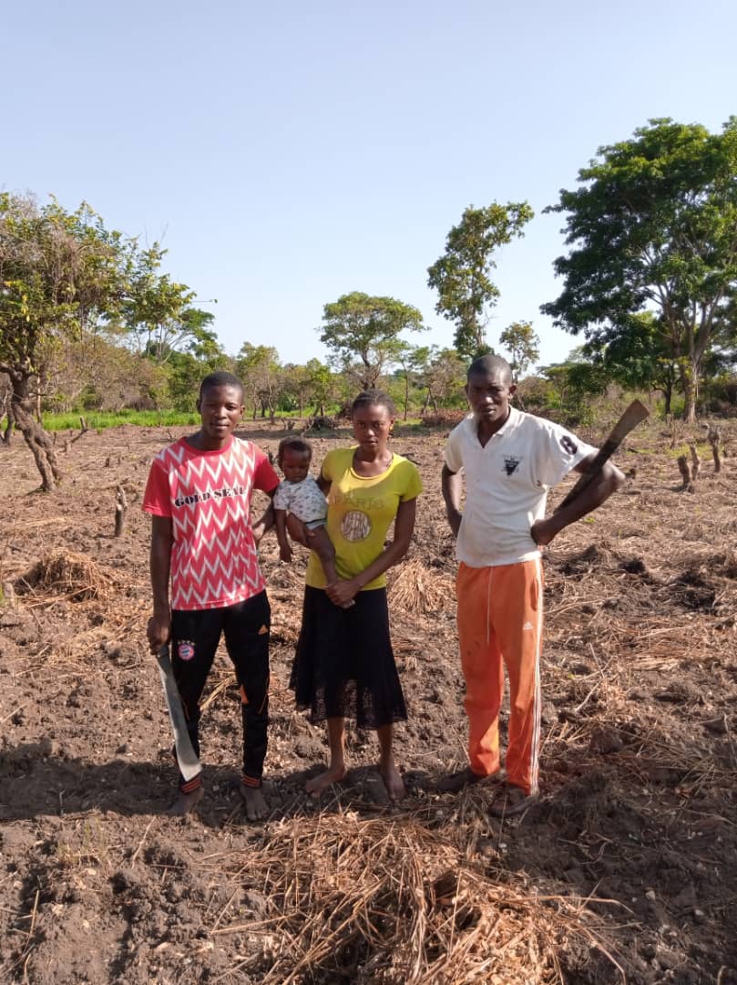 A group of people are posing for a picture in a field.