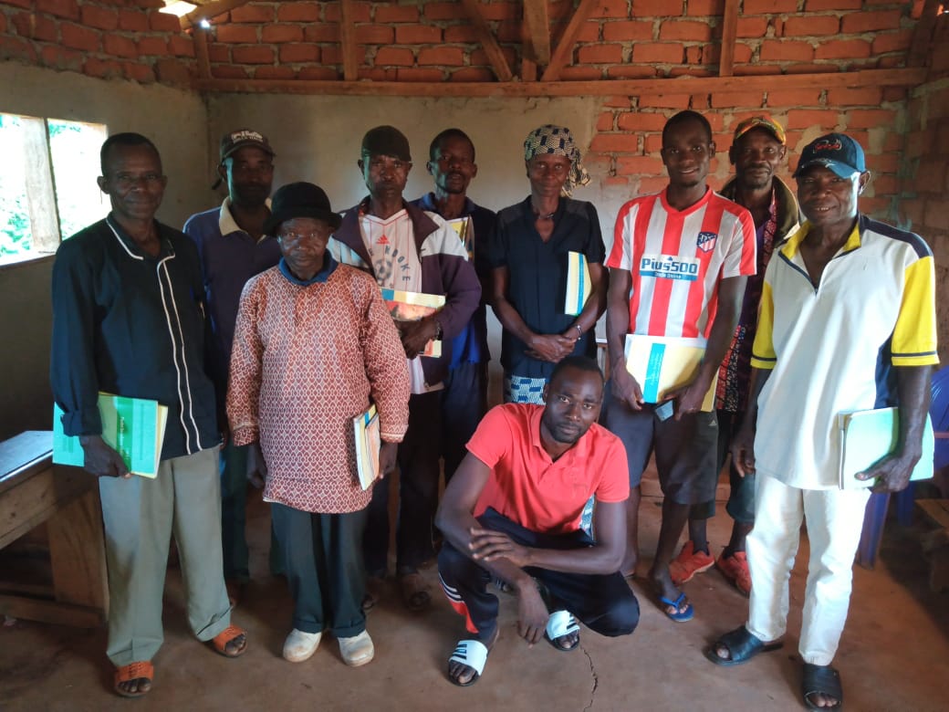 A group of people posing for a picture with one man wearing a shirt that says ' adidas ' on it