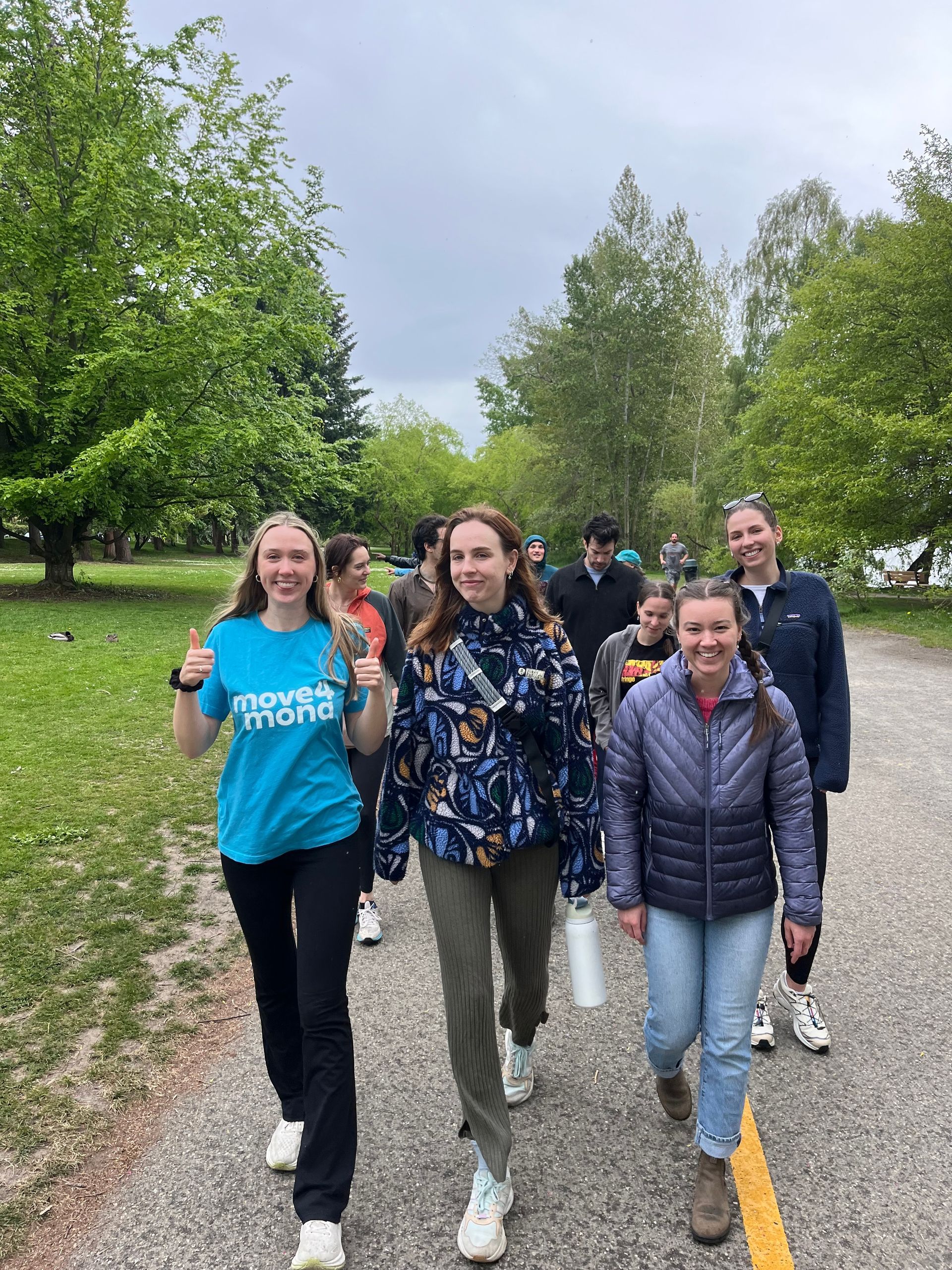 A group of people are walking down a path in a park.
