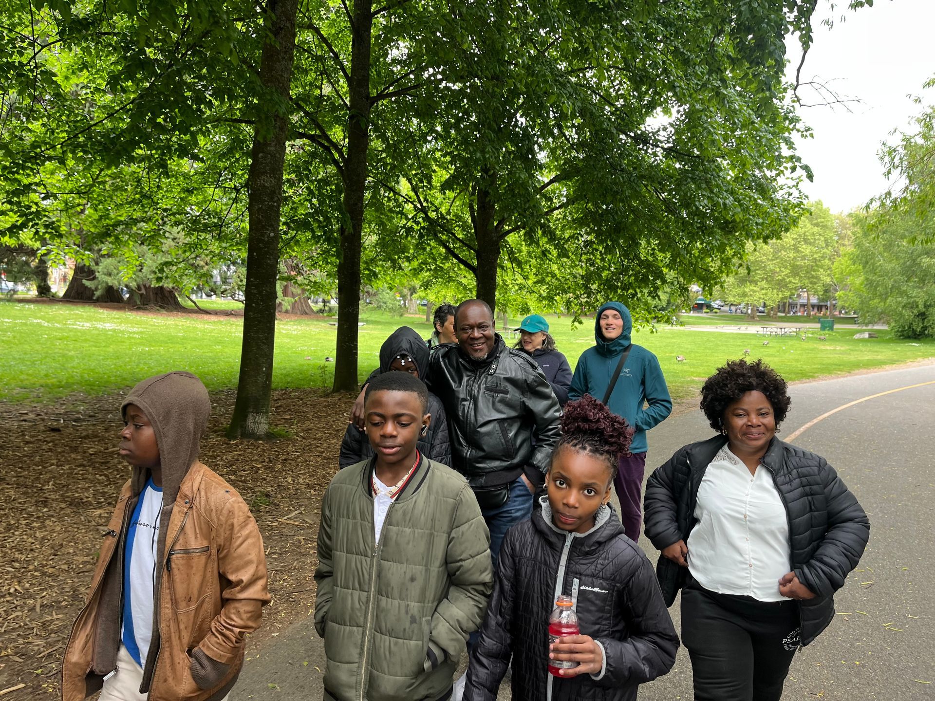 A group of people are walking down a path in a park.
