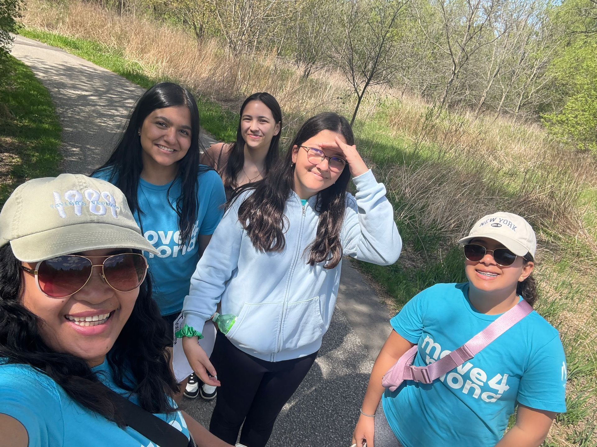 A group of young women are standing next to each other on a path.