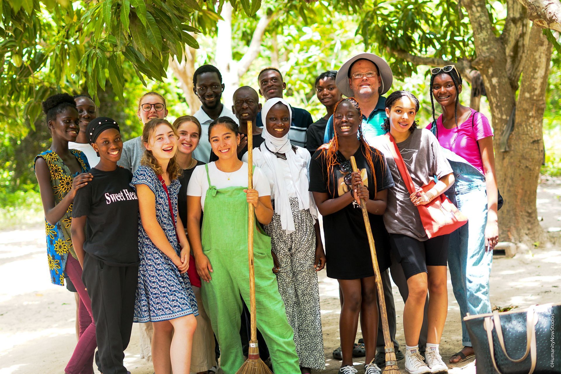 A group of people are posing for a picture with trees in the background.