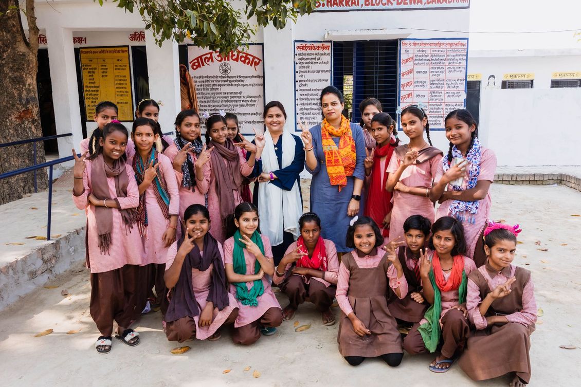 A group of young girls are posing for a picture in front of a building.