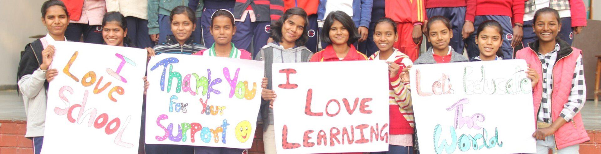 A group of children are holding signs that say thank you i love learning