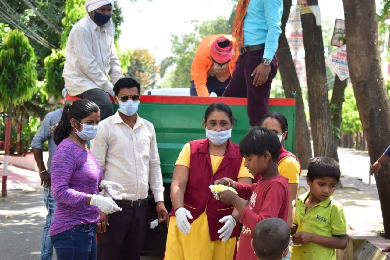 A group of people wearing masks and gloves are standing in front of a truck.