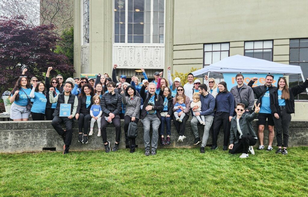 A large group of people are posing for a picture in front of a building.