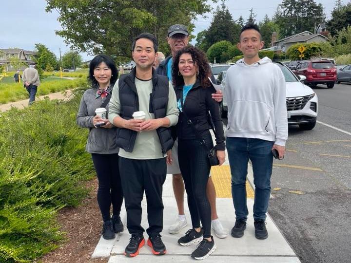 A group of people are posing for a picture in a parking lot.