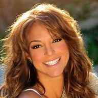 A woman with long brown hair is smiling for the camera.