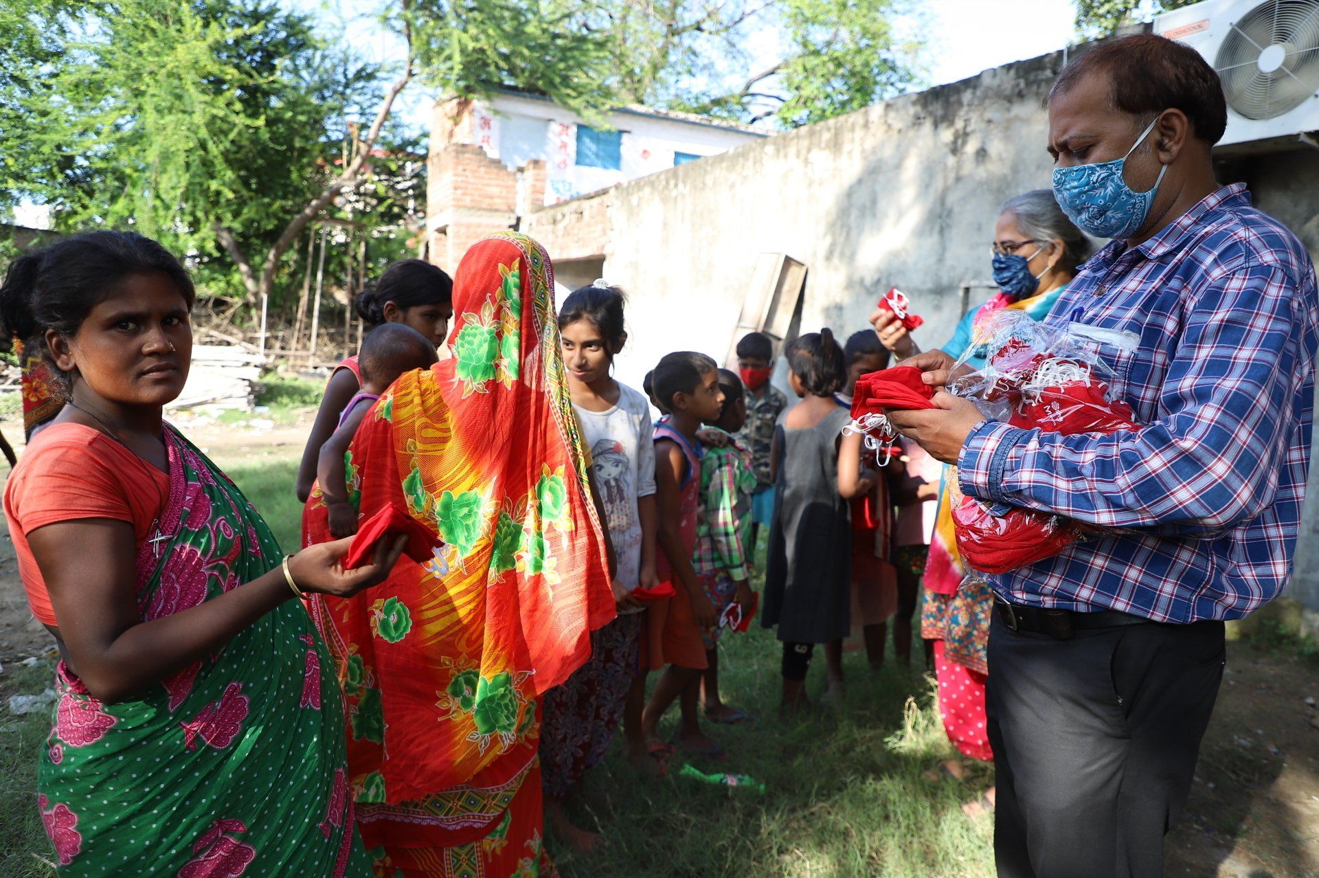 A man wearing a mask is standing in front of a group of people.