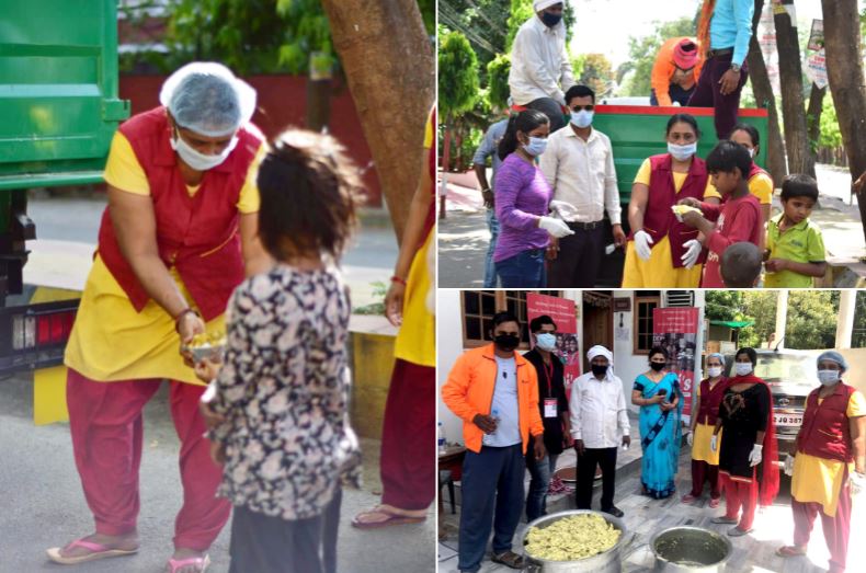 A woman wearing a mask is feeding a child.