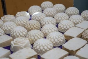 A bunch of white soaps are sitting on top of each other on a table.
