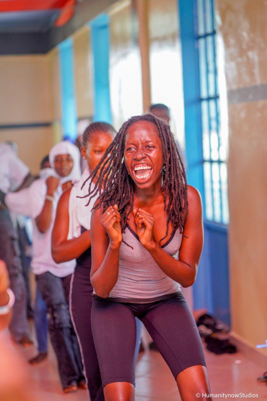 A woman is dancing in a room with other people.